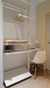 Una habitación blanca con un escritorio y una silla. en Le Petit Palü-Fuencarral, en Madrid