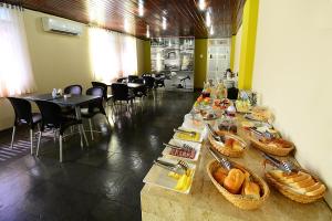 a long table with food on it in a restaurant at Hotel Imperial in Mossoró