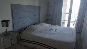 マルセイヤンにあるport rive gauche pavoisのベッドルーム1室(大型ベッド1台、木製ヘッドボード付)