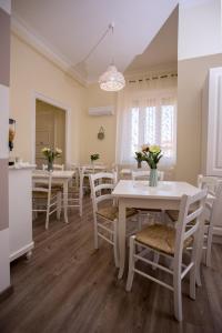 uma sala de jantar com mesas brancas e cadeiras brancas em Il Sonaglio em Palermo