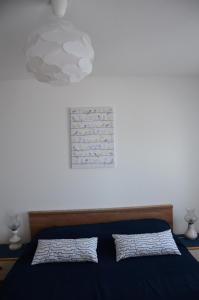 1 dormitorio con 1 cama azul y 2 almohadas en Apartmani Gale, en Okrug Donji