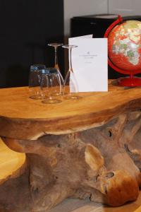 a wooden table with wine glasses on top of a tree stump at villa les champs de knokke in Knokke-Heist