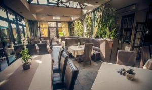 a dining room with tables and chairs and plants at Villa Garden Kutno Centrum in Kutno