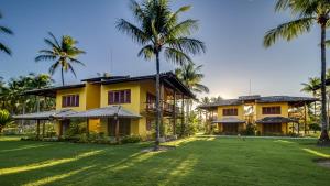 an exterior view of a house with palm trees at Villa dos Corais in Morro de São Paulo