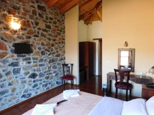 Habitación con cama y pared de piedra. en Akrothea Hotel, en Goura