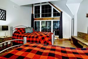 een slaapkamer met een bed, een bank en een raam bij Le Sto Shack 25 Chemin Blanc by Les Chalets Alpins in Stoneham