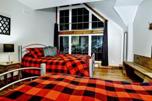 Un dormitorio con una cama y un sofá y una ventana. en Le Sto Shack 25 Chemin Blanc by Les Chalets Alpins, en Stoneham