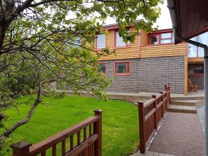 uma casa com uma cerca de madeira e um quintal em Holiday Guesthouse em Stykkishólmur