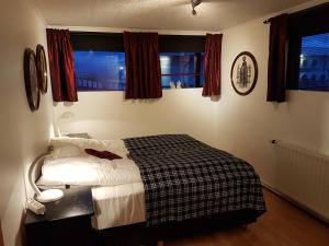 um quarto com uma cama e duas janelas em Holiday Guesthouse em Stykkishólmur