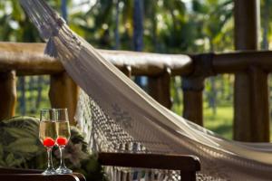 a glass of wine is sitting on a hammock at Villa dos Corais in Morro de São Paulo