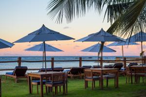 a group of tables and chairs with umbrellas on the beach at Villa dos Corais in Morro de São Paulo