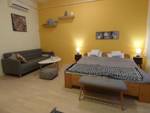 a bedroom with a bed and a couch in a room at Yellow Apartment in Debrecen