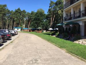 a road next to a building with parked cars at Pati Ferien Apartmens in Łukęcin