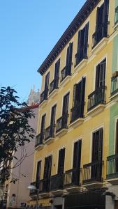un edificio amarillo con puertas y ventanas negras en Le Petit Palü-Fuencarral, en Madrid