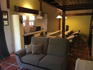 a living room with a couch and a row of stools at Quinta do Rossio, Rural Tourism in Biscoitos