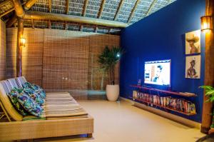 a living room with a couch and a tv at Villa dos Corais in Morro de São Paulo