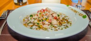 a white bowl of food with rice and chicken at Villa dos Corais in Morro de São Paulo