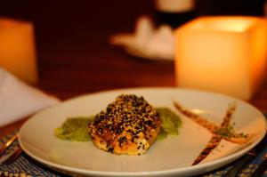 a white plate with a piece of food on a table at Villa dos Corais in Morro de São Paulo