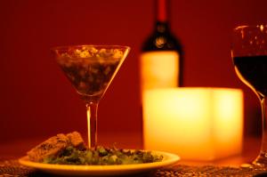 a glass of wine and a plate of food on a table at Villa dos Corais in Morro de São Paulo