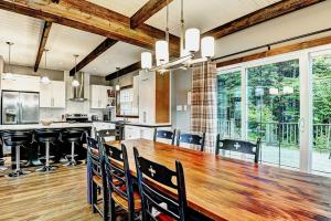 a large kitchen with a large wooden table and chairs at Chalet 9010 Chemin des Alpages by Les Chalets Alpins in Stoneham