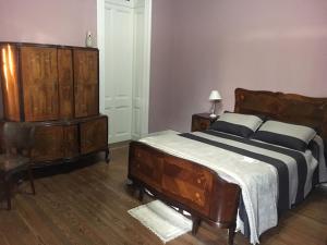 a bedroom with a bed and a wooden dresser at Carmine Hotel Apart in Capilla del Señor +44 photos