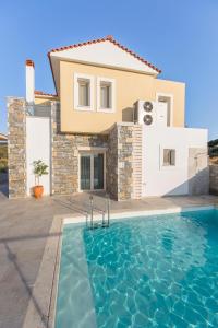 a villa with a swimming pool in front of a house at Virginia Luxury Villas in Palaiókastron