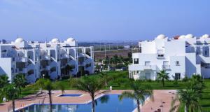 uitzicht op enkele witte gebouwen en een zwembad bij Chez Younès Appartement Marina Saidia Ap8 in Saidia 