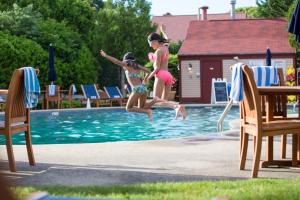 two young girls jumping into a swimming pool at The Mansion at Ocean Edge Resort & Golf Club in Brewster