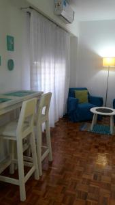 sala de estar con mesa, sillas y sofá en Distrito Palermo Apartment en Buenos Aires