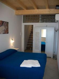 Cama azul en habitación con escalera en Affittacamere La Darsena, en Portovenere