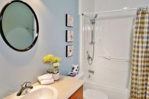 a bathroom with a sink and a mirror and a shower at Chalet 9017 Chemin des Alpages by Les Chalets Alpins in Stoneham +28 photos