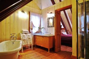 a bathroom with a tub and a sink and a bed at Chalet 9017 Chemin des Alpages by Les Chalets Alpins in Stoneham