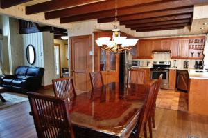 a kitchen with a dining room table and chairs at Chalet 9017 Chemin des Alpages by Les Chalets Alpins in Stoneham