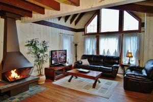a living room with a couch and a fireplace at Chalet 9017 Chemin des Alpages by Les Chalets Alpins in Stoneham