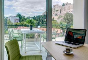 um computador portátil sentado numa mesa numa varanda em Frixos Acropolis Luxury Apartment em Atenas