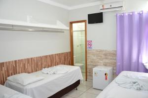 a hotel room with a bed and a shower at Hotel Cerrado in Goiânia