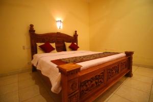 a bedroom with a wooden bed in a room at Adi Santia Bungalows in Ubud