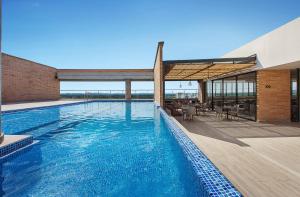 a swimming pool with blue water in a building at Hotel Sites Montería in Montería