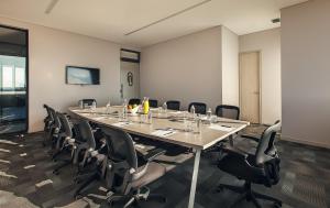 uma sala de conferências com uma mesa longa e cadeiras em Hotel Sites Montería em Montería