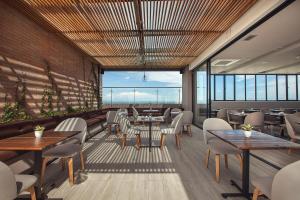 a restaurant with tables and chairs and a large window at Hotel Sites Montería in Montería