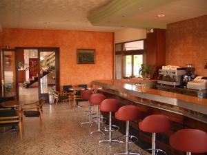 a restaurant with a bar with red stools at Hotel Sant Jordi in Tarragona