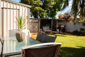a glass table with chairs and a potted plant at Bidgee Motor Inn in Hay