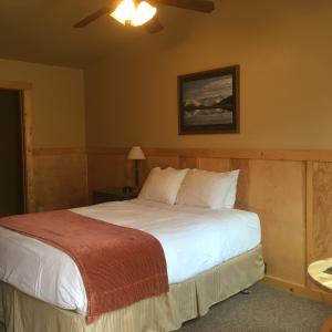 a bedroom with a bed and a lamp at McKinley Creekside Cabins in McKinley Park