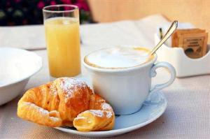 a plate with a cup of coffee and a pastry at marangatu apart hotel in Puerto Iguazú