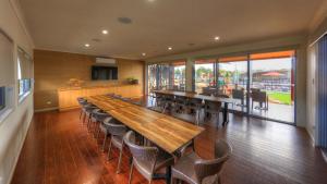 a dining room with a large wooden table and chairs at Ingenia Holidays Rivershore in Maroochydore