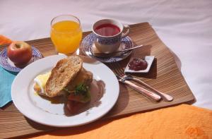 a plate of food with a sandwich and a cup of orange juice at 6 Suites Hotel in Bogotá