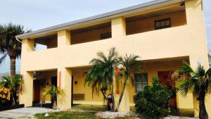 a building with palm trees in front of it at Sunset Inn- Fort Pierce, FL in Fort Pierce