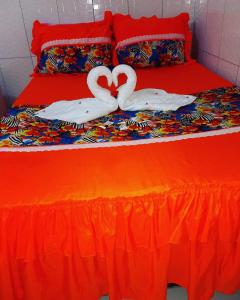 Dos cisnes forman un corazón en una cama en Pousada Estrela Do Mar, en Maragogi