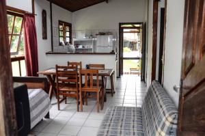 a kitchen and dining room with a table and chairs at Coppas'cabanas in Boicucanga