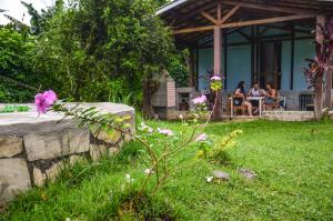 a group of people sitting outside of a house at Coppas'cabanas in Boicucanga